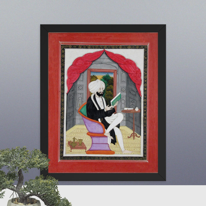 A Sikh Sardar reading from a book, seated in front of a window - Framed Print - SRI ASDHUJ