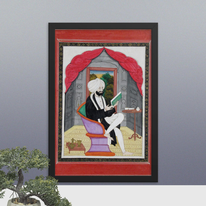 A Sikh Sardar reading from a book, seated in front of a window - Framed Print - SRI ASDHUJ